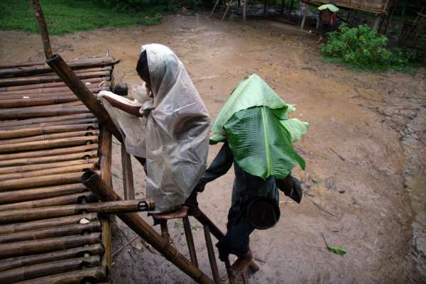 Downpour as a grandmother and grandson arrive home from a day in the swiddens.