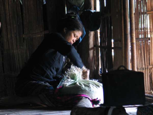 A villager packs provisions for a long hike downstream.