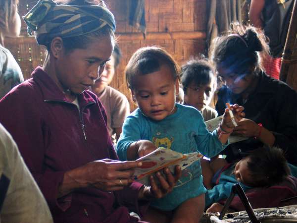 The ethnographer brings prints of photographs to Mrka taken from a prior visit: this is cause for an impromptu celebratory gathering in the village head's house. Here an aunt and niece enjoy the excitement of new photos.