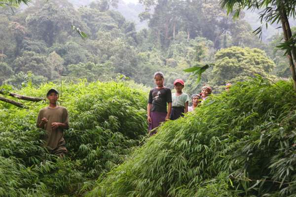 Family members at water's edge after a day's work in their swiddens wait for boats to cross the Ñrong River and return home to Mrka Kơn Hamlet.